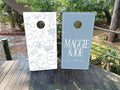 Custom dusty blue and white wedding cornhole wraps with names and custom icons