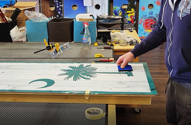 Person applying a cornhole wrap