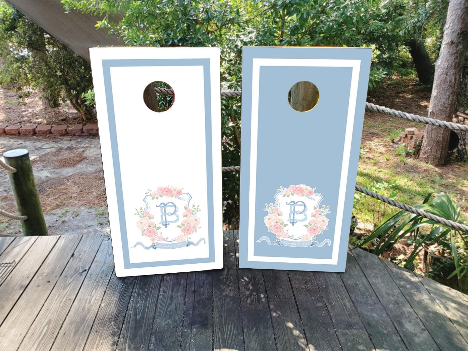 cornhole wraps in a dusty blue and white with a custom wedding crest
