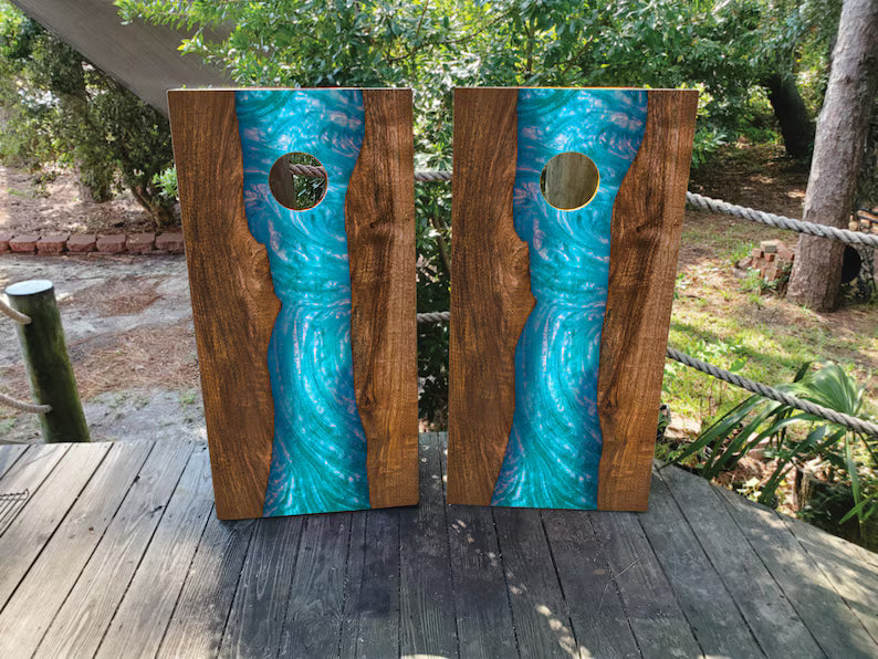 Epoxy river style cornhole wraps featuring turquoise resin design with realistic wood grain on regulation cornhole boards