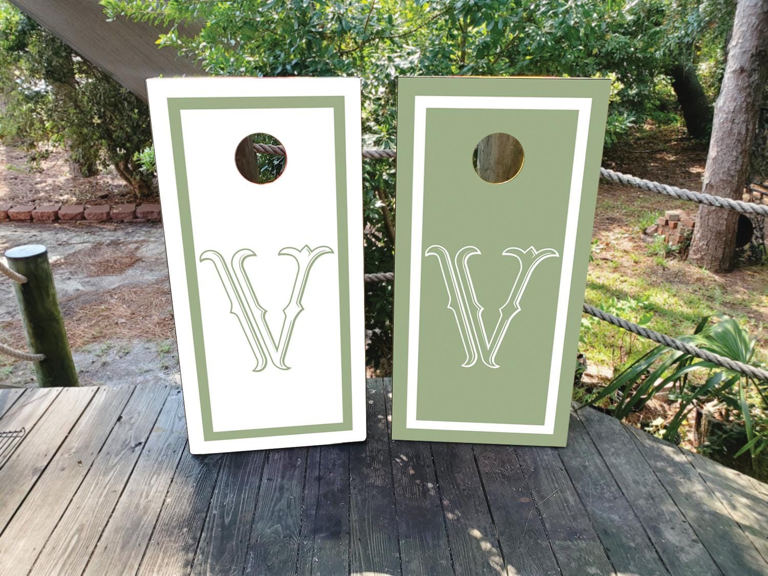 cornhole wraps in a dusty green and white with a custom wedding crest