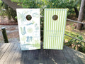 cornhole wraps featuring a custom wedding design with custom icons, stripped green and custom names