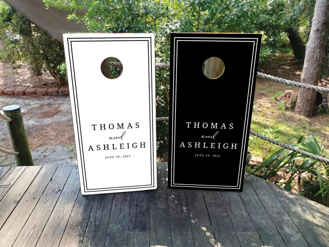 Black and white personalized wedding cornhole wraps featuring a modern bordered design with custom names and wedding date on regulation boards